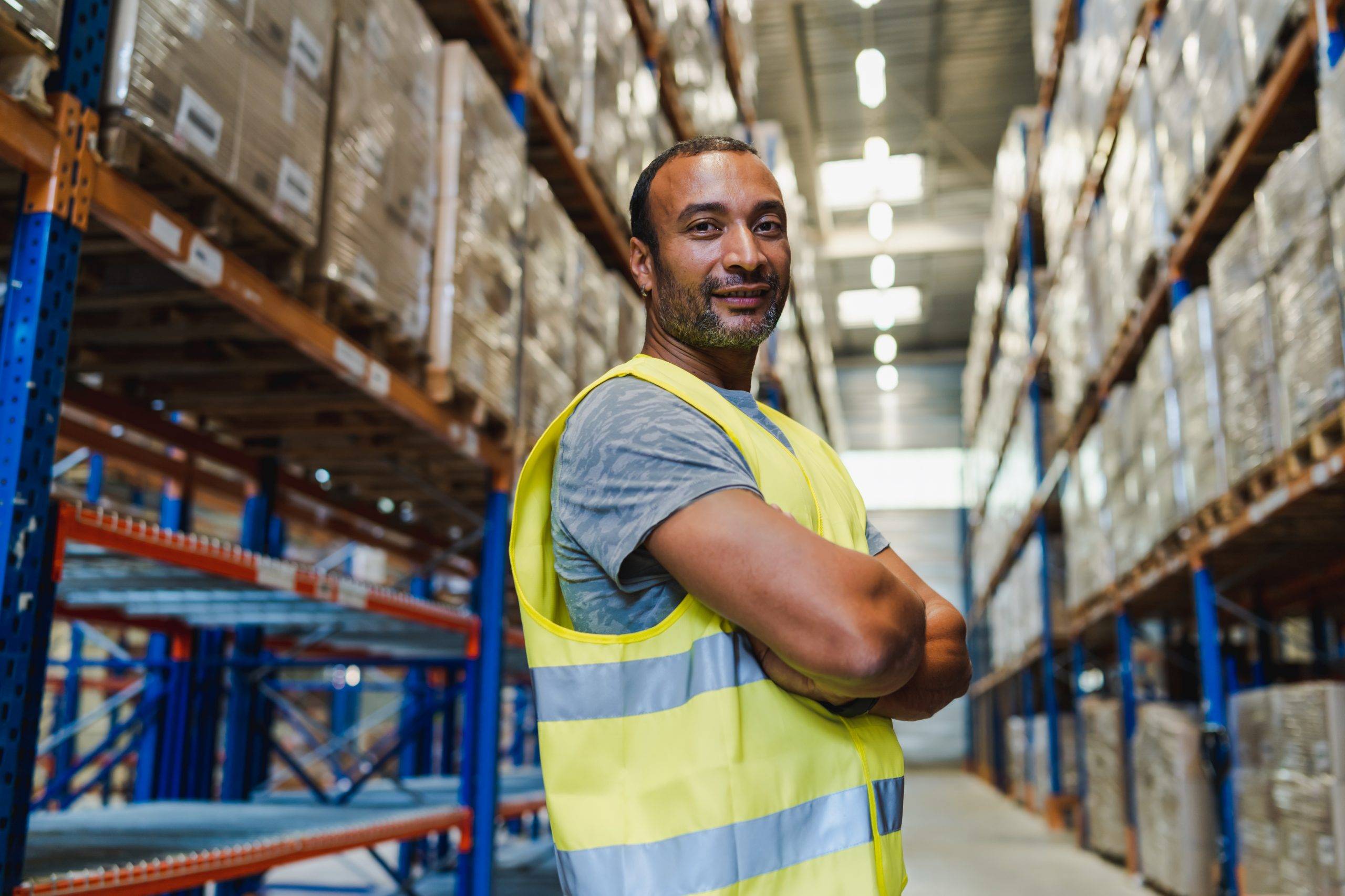 Essential worker standing in warehouse aisle
