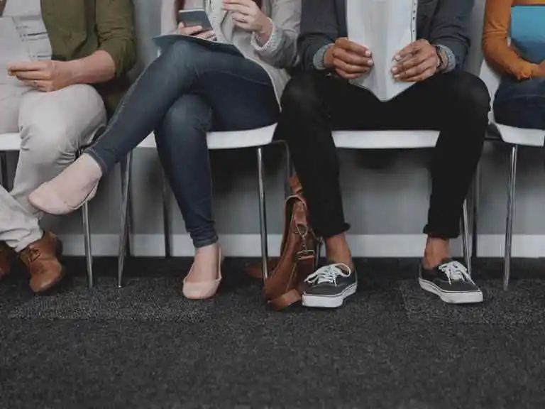 Close up of diverse legs waiting in a waiting room