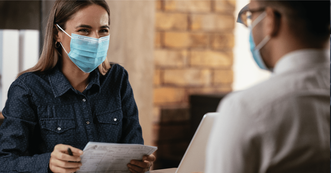 Woman in mask interviewing a candidate